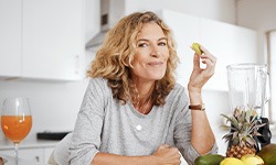 Woman leaning on counter eating apple