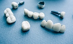 Various types of dental implants in Frisco on blue background