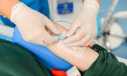 Dental team member placing IV in patient’s arm