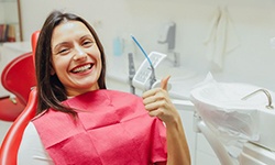 Happy dental patient making thumbs up gesture