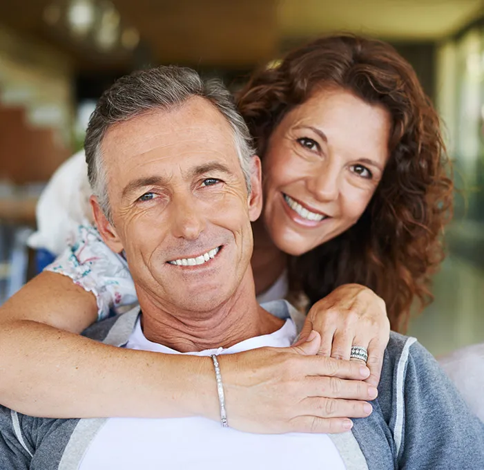 Happy couple embracing, showing bright smiles
