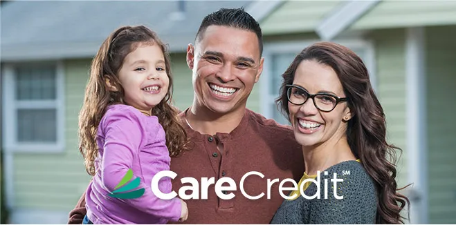 Happy family with CareCredit logo - father, mother and young daughter smiling