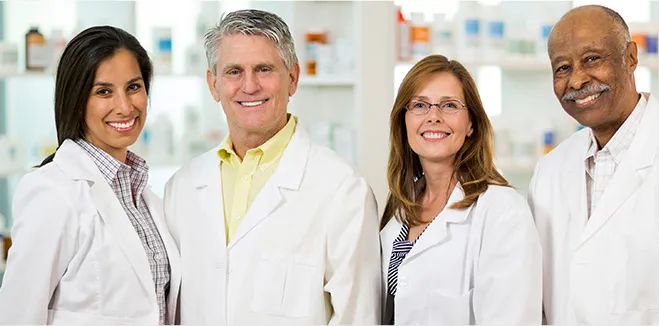 Diverse team of dental professionals in white coats smiling