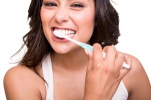 A woman brushing her teeth.