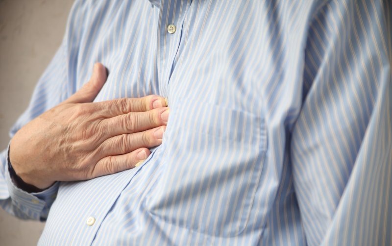 A man covering his chest with his hand.