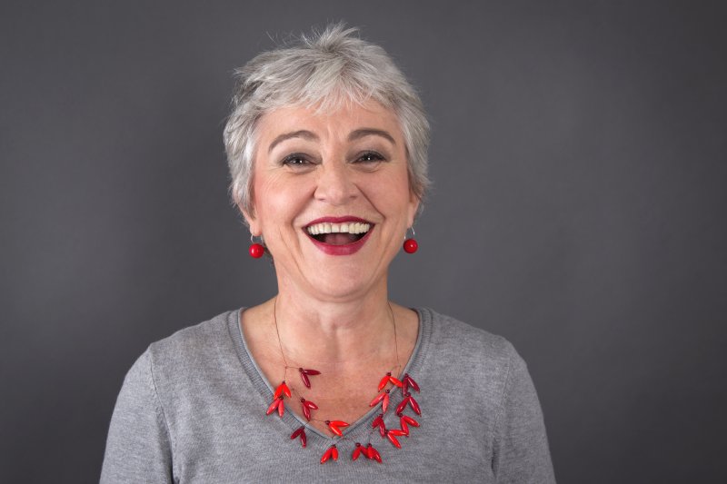 Woman smiling after visiting a periodontist in Frisco.