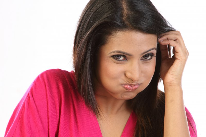 Woman using mouthwash to prevent gum disease in Frisco.