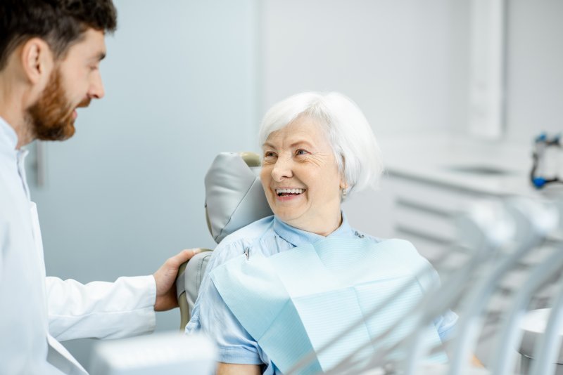 Periodontist explaining implant dentures in Frisco to patient