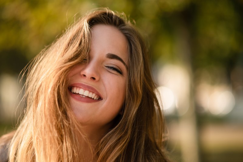 woman smiling outside in the sun