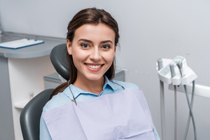 Female patient sitting in treatment chair and smiling